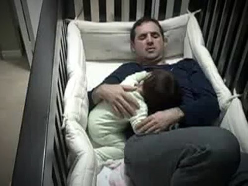 Papa schläft im Baby im Kinderbett