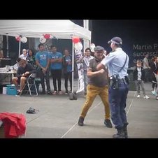 Filigrane Polizistin tanzt mit älterem Herrn