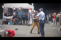 Filigrane Polizistin tanzt mit älterem Herrn